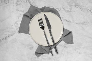 Stylish setting with elegant cutlery on white marble table, top view