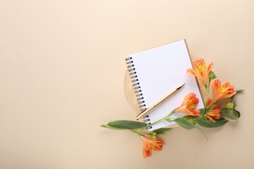 Guest list. Notebook, pen and beautiful flowers on beige background, top view. Space for text