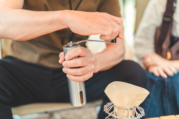 コーヒーミルでコーヒー豆を挽く男性の手元

