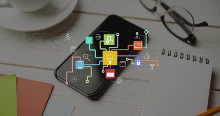 Image of network of icons over smartphone on desk
