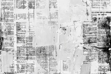 An image of a wall covered with waste paper and old newspapers. Antique documents and dirty and torn printed writings.