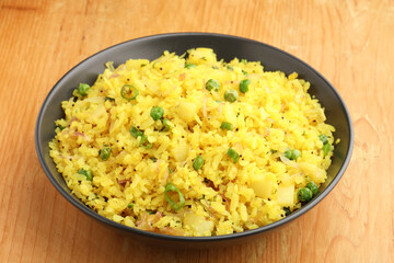 Indian Breakfast Dish Poha Also Know as Pohe or Aalu poha made up of Beaten Rice or Flattened Rice. The rice flakes are lightly fried in oil with mustard, turmeric, onion, curry leaves
