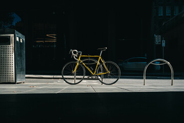 Yellow Bicycle in Bike Rack at Sunrise 