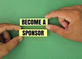 hand holding colored paper with the words become a sponsor