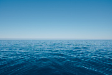 A vast expanse of deep blue sea, with the horizon line stretching across an endless sky of clear and unbroken light blue color, ripples - Powered by Adobe