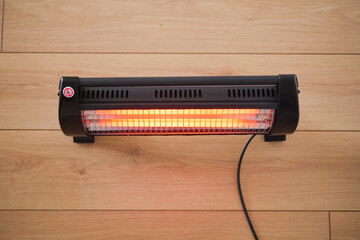 Modern electric infrared heater in living room, closeup