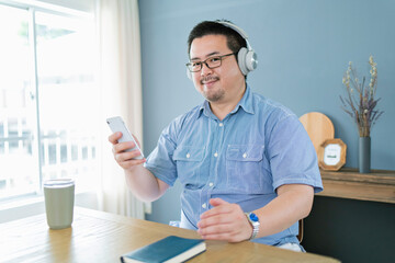 スマートフォンを見ながら音楽を聴く大柄な日本人男性