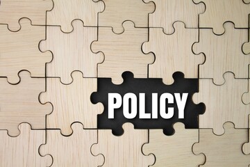 wooden puzzle with the word policy. basic concepts or organizational policies