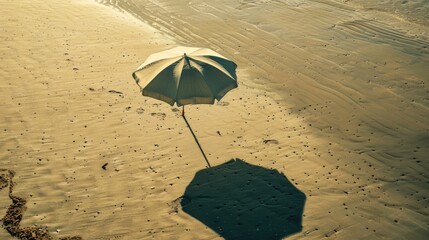 An umbrella rests on the sandy shore of the beach, overlooking the vast expanse of water. Travelers enjoy the scenic landscape as they relax on the shore AIG50