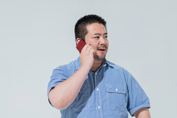 スマートフォンで電話をする大柄な日本人男性