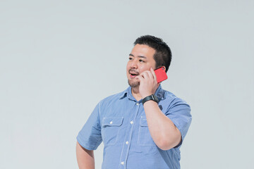 スマートフォンで電話をする大柄な日本人男性