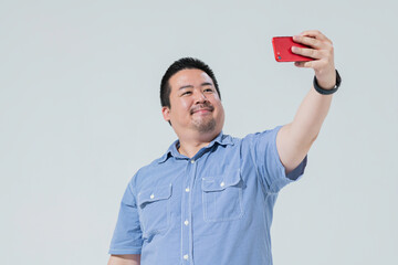 スマートフォンで自分の写真を撮る大柄な日本人男性