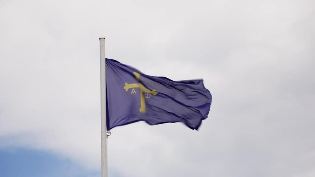 Cross flag soaring in sky