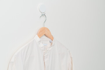 hanging shirt with wood hanger on wall