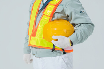 ヘルメットを抱えた作業員の男性