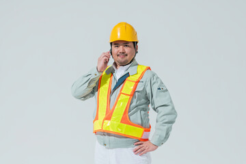 スマートフォンで電話をする作業服の男性