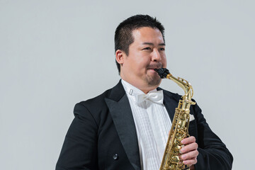 サックスを演奏する大柄な日本人男性