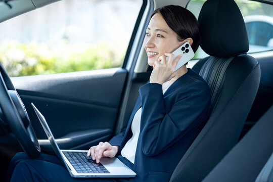 車内で電話をするスーツを着た女性