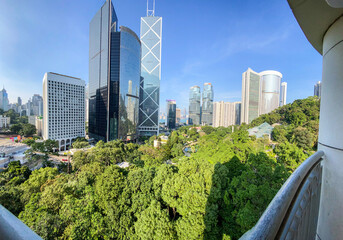 Fototapeta premium Urban Oasis: Green Park Amidst Soaring Skyscrapers, Hong Kong