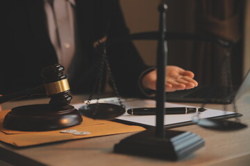 Business and lawyers discussing contract papers with brass scale on desk in office. Law, legal services, advice, justice and law concept picture with film grain effect
