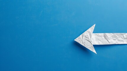 Clean, white arrow crafted from paper, set against a cobalt blue backdrop, illustrating the path to career success and development