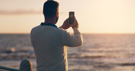 Man, phone and photography for sunset by ocean on vacation with memory, post and horizon in summer....