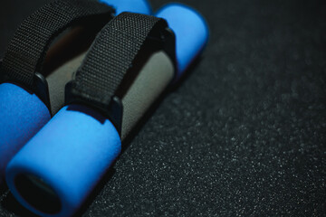 View of blue dumbbells on a black background. Workout equipment for training at home top view....