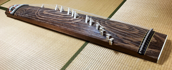 A Koto, a traditional 13 stringed instrument on the tatami mats of a Japanese-style room. The whole...