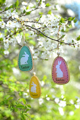 Decorative colored Easter egg with Easter bunny on a cherry blossom branch