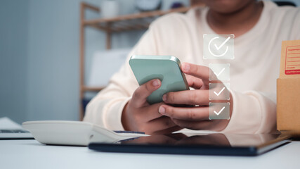 Business women holding smartphone with a checked box on Excellent Smiley Face and Rating for a satisfaction survey, Evaluation of product service quality by customers, Positive customer feedback.