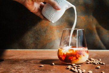 a glass of homemade cold cold brew coffee with ice on rustic table background.