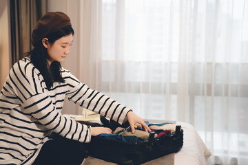 Young Woman Organizing Suitcase for Travel