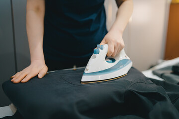Woman Efficiently Ironing Clothes on Ironing Board