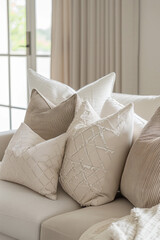 A set of modern geometric throw pillows with monochromatic patterns or subtle textures, arranged on a neutral-colored sofa, adding depth and sophistication to the decor. 