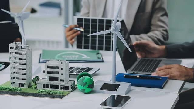 Business people having consultation about wind energy at company office. Business team discussing about windmill and alternative green enery. Net zero and carbon neutral concept