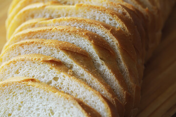 long loaf on a wooden board and knife isolated on a white background. Tasty bread