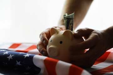 Closeup view of an American flag with a pink piggy bank for various financial concepts.