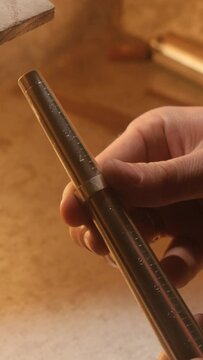 The jeweler checks the size of the ring with a special tool. Vertical video.
