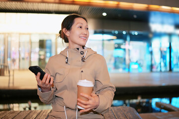 Smiling Woman with Smartphone Enjoying City Life