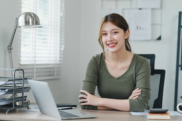 Confident young asian businesswoman using laptop at modern home office.