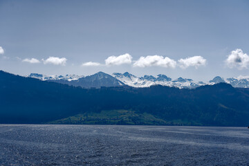Rural landscape in the Swiss Alps seen from passenger ship running on Lake Lucerne between Kehrsiten and City of Lucerne on a sunny spring day. Photo taken April 11th, Lake Lucerne, Switzerland.