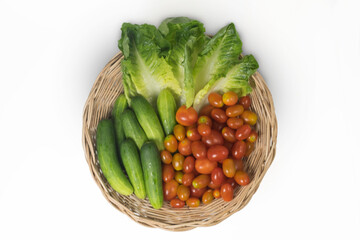 fresh vegetables,cucumbers, tomatoes
, and cos lettuce,  in wicker basket or rattan basket, isolated on white background with clipping path, top view, flat lay.