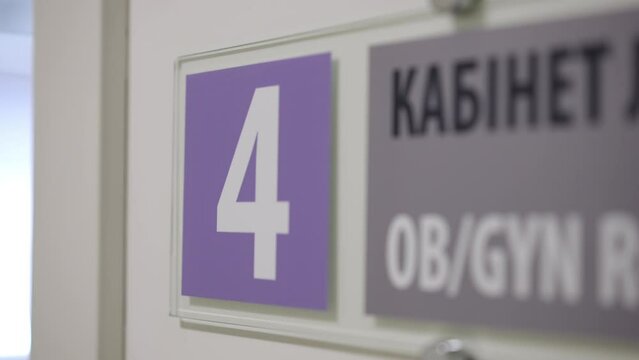 This video shows a detailed close-up of a sign mounted on a wall. The camera zooms in to show a sign for a gyn room.