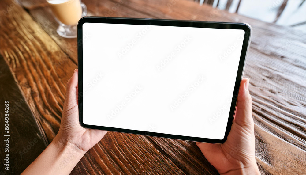 Poster mockup image of a hand holding digital tablet with blank white desktop screen