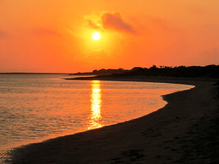 A golden sunrise, with the sun reflecting in a small secluded bay at the Portuguese islands along...
