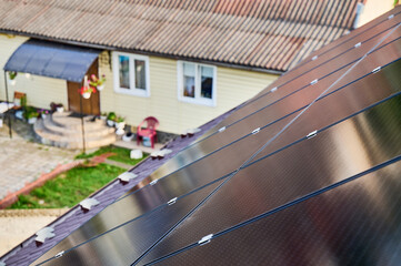 Solar panels installed on sloped roof of suburban home. Panels angled to capture sunlight....