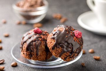 Round chocolate cakes. Decorated with candied raspberries. Dark background