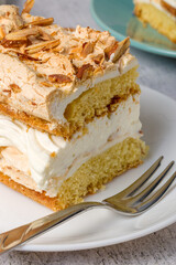 Norwegian cake. With meringue, whipped cream and almonds. Light background