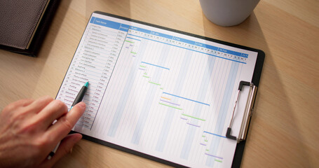 Close-up Of Businessman With Pen Working On Gantt Chart