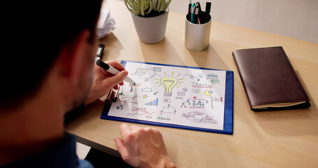 Businessman Preparing Startup Plan On Paper At Table